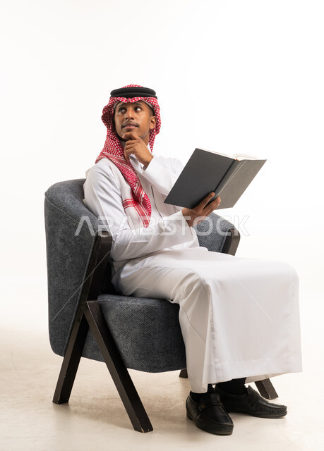 Saudi Man Reading Book on Chair White Background