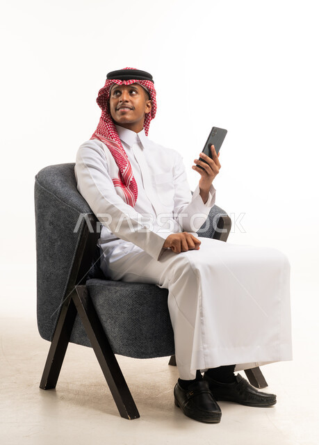 Saudi Man in Traditional Dress with Smartphone in Studio