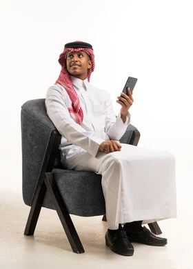 Saudi Man in Traditional Dress with Smartphone in Studio