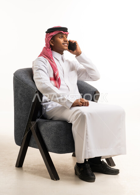 Saudi Man in Traditional Thobe Talking on Smartphone