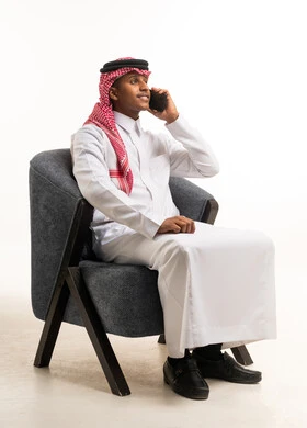 رجل سعودي بالزي التقليدي يتحدث عبر الهاتف المحمول