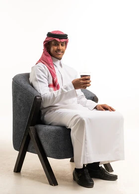 Saudi Man in Traditional Dress Sitting in Armchair