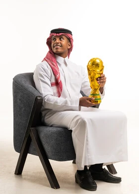 Saudi Man in Traditional Thobe Holding World Cup Trophy