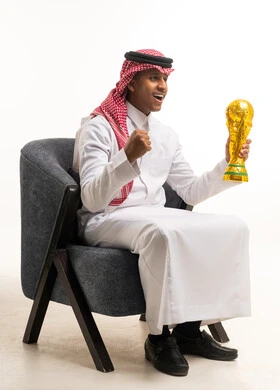 رجل سعودي يحمل كأساً ذهبياً بالثوب التقليدي