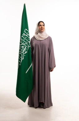 امرأة سعودية مع علم السعودية في الاستوديو