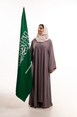 امرأة سعودية بالعباءة تحمل العلم السعودي خلفية بيضاء