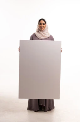 امرأة إماراتية تحمل لوحة بيضاء فارغة في الاستوديو