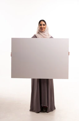 امرأة سعودية تحمل لوحة إعلانية بيضاء فارغة