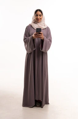 Saudi Woman in Abaya Using Smartphone in Studio