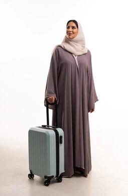 امرأة سعودية مع حقيبة سفر في الاستوديو