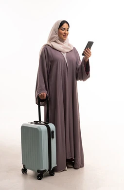 Saudi Woman with Suitcase and Smartphone for Travel