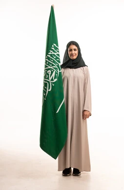 امرأة سعودية مع علم المملكة العربية السعودية في الاستوديو