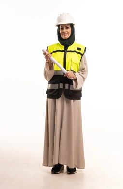 مهندسة سعودية بالعباءة تحمل مخططاً معمارياً وخوذة أمان