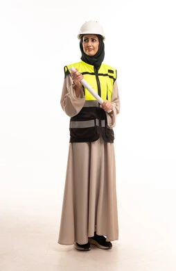 مهندسة عربية بملابس السلامة تحمل مخططاً معمارياً