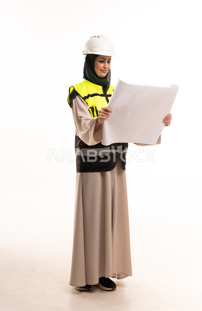 Saudi Female Engineer Reviewing Architectural Blueprint