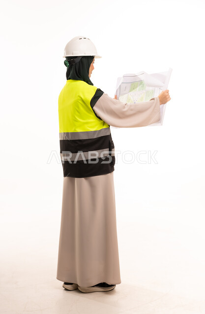 Saudi Female Engineer Reviewing Blueprints in Studio