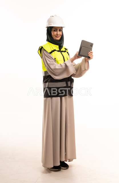 مهندسة سعودية ترتدي خوذة وسترة سلامة وتستخدم تابلت