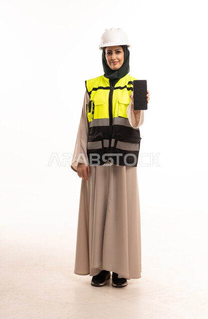 Arab Female Engineer Holding Smartphone in Safety Gear
