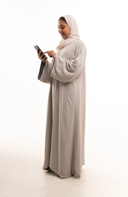 امرأة سعودية بالعباءة تستخدم الهاتف في الاستوديو