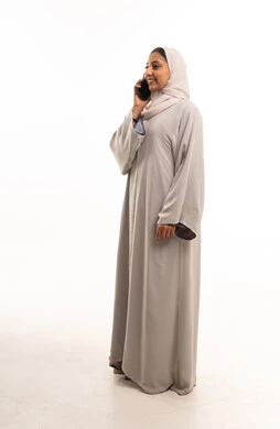 امرأة سعودية بالعباية تتحدث بالهاتف في الاستوديو