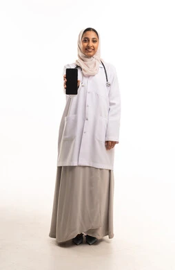 طبيبة سعودية تحمل هاتفاً ذكياً على خلفية بيضاء