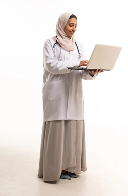 طبيبة سعودية تستخدم جهاز كمبيوتر محمول في الاستوديو