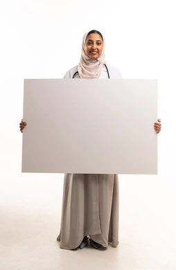 طبيبة سعودية تحمل لوحة بيضاء فارغة للنصوص