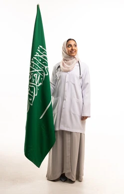 طبيبة سعودية ممسكة بعلم المملكة العربية السعودية