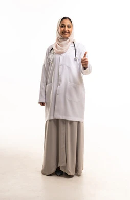 طبيبة سعودية بالمعطف الأبيض تعطي إشارة النجاح والرضا