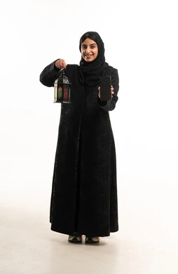 امرأة إماراتية تحمل هاتفاً ذكياً وفانوس رمضان امرأة إماراتية تحمل هاتفاً ذكياً وفانوس رمضان