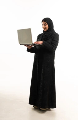 امرأة سعودية بالعباءة تستخدم الكمبيوتر المحمول خلفية بيضاء