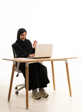 امرأة سعودية على المكتب تلوح خلال مكالمة فيديو