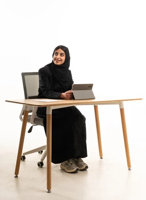 Saudi Woman in Abaya Working at Office Desk with Tablet
