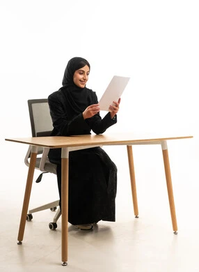 سيدة أعمال سعودية تقرأ وثيقة في مكتب عصري