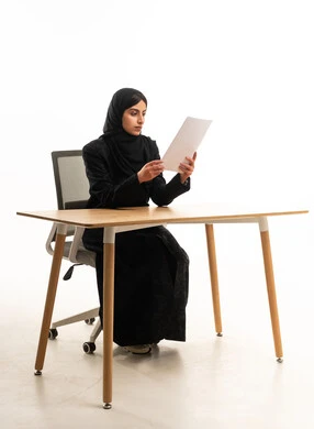 Arab Businesswoman Reading Document at Desk Studio Shot
