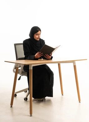 Arab Woman in Abaya Reading Book at Desk