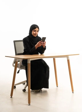 Arab Woman in Abaya Using Smartphone at Office Desk