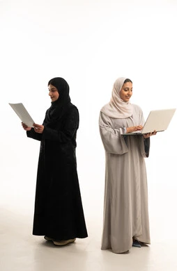 سيدات أعمال سعوديات بالعباءة مع لابتوب ووثيقة
