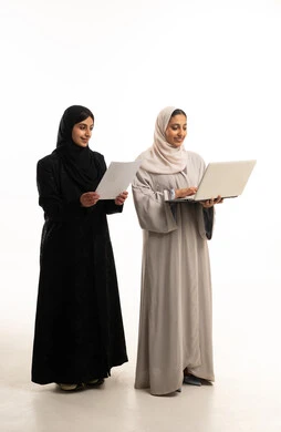 Emirati Businesswomen in Abayas with Laptop and Paper