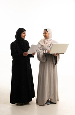 سيدات أعمال عربيات بالعباية مع جهاز حاسوب محمول