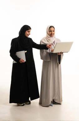 سيدات أعمال إماراتيات مع حاسوب محمول بخلفية بيضاء