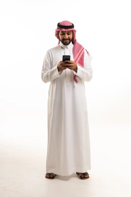 رجل سعودي بالزي التقليدي يستخدم الهاتف الذكي في الاستوديو