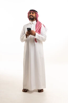 رجل سعودي بالزي التقليدي يمسك هاتف ذكي