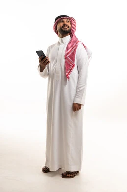 رجل سعودي مع هاتف ذكي في استوديو بخلفية بيضاء