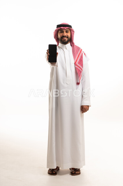 رجل سعودي يمسك هاتف ذكي بخلفية بيضاء