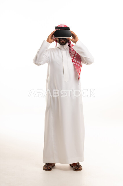 رجل سعودي بالثوب التقليدي يستخدم نظارة الواقع الافتراضي