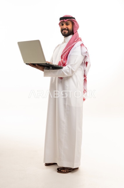 رجل سعودي بالزي التقليدي يستخدم المحمول بخلفية بيضاء