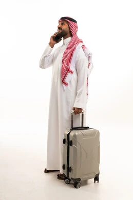 رجل سعودي مع حقيبة سفر يتحدث بالهاتف