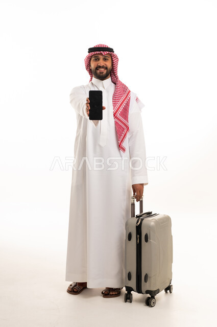 رجل سعودي مع حقيبة سفر وهاتف ذكي خلفية بيضاء