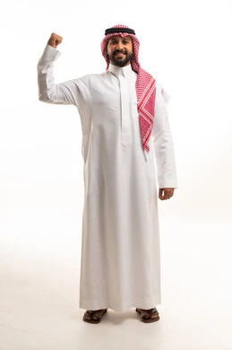 A Saudi man in traditional attire showcases his muscles and strength.